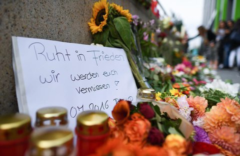 Blumen und Kerzen in der Nähe des Olympia-Einkaufszentrums, auf einem Zettel steht