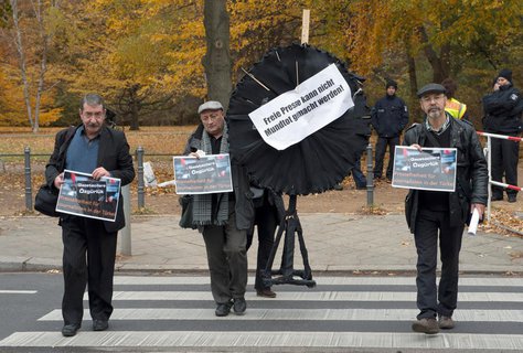 Mitglieder des Bundes türkischer Journalisten in Europa gehen am Freitag in Berlin mit Plakaten und einem schwarzen Kranz zur türkischen Botschaft. Nach der Verhaftung zahlreicher Journalisten in der Türkei, hatte der Bund türkischer Journalisten in Europa zu der Protestaktion vor dem Botschaftsgebäude aufgerufen.