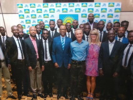 Gasore (rechts der zentralen Sonne), sein Trainer Jonathan und Präsident Kagame.