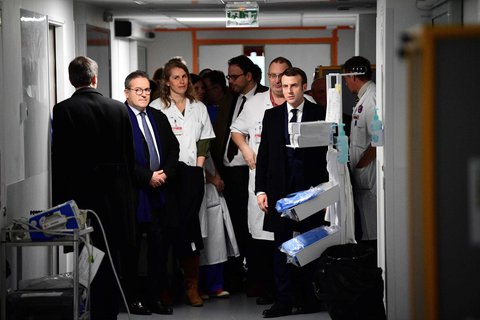 Frankreichs Präsident Macron (r) und Gesundheitsminister Olivier Veran (l) besuchen ein Krankenhaus in Paris, in dem es am Tag zuvor den ersten Todesfall infolge des Coronavirus gab. 