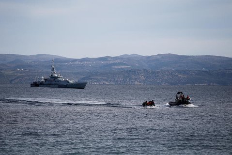 Ein Rettungsboot begleitet ein kleines Boot mit Flüchtlingen, im Hintergrund ein Frontex-Schiff, bei Lesbos. 