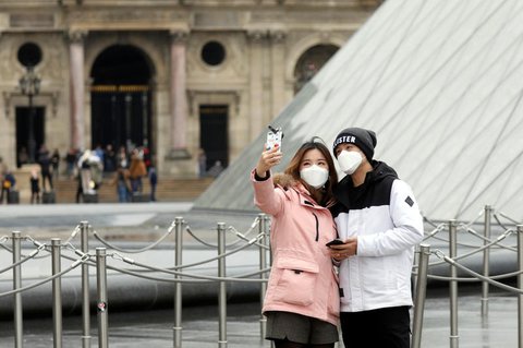 Mit Schutzmasken vor dem Louvre.