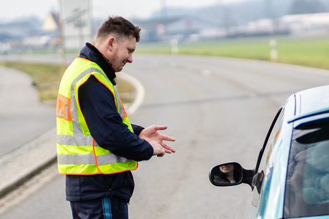 In Mitterteich in Bayern kontrolliert ein Polizist, ob die Person im Auto zurecht draußen unterwegs ist.