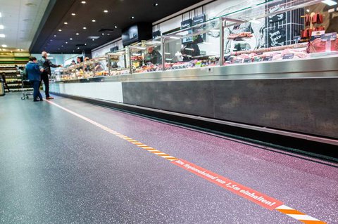 Eine Abstandsmarkierung in einem Supermarkt.