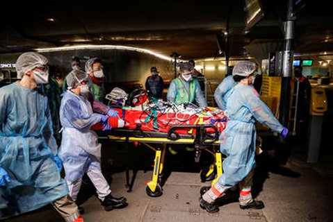 Medzinisches Personal beim Abtransport eines COVID-19-Patienten.
