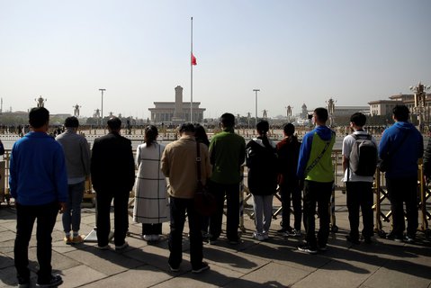 Menschen stehen am Tiananmen  Platz in Peking und gedenken der Toten der Coronavirus-Epidemie.