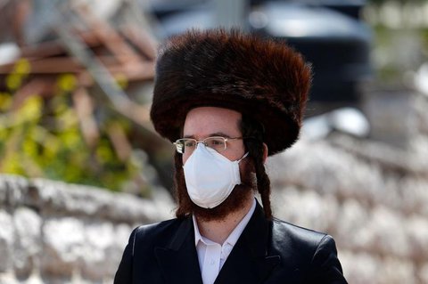 Ein Mitglied der ultra-orthodoxen jüdischen Gemeinde mit Schutzmaske.