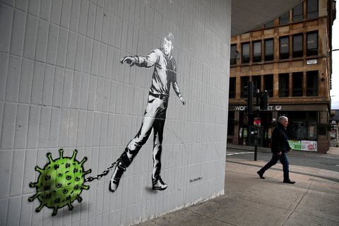 Der Künstler Rebel Bear thematisiert in seinem Werk in Glasgow, wie der Mensch an das Coronavirus gekettet ist.