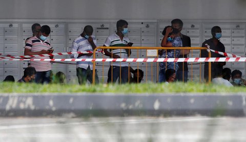 Arbeitsmigranten in Singapur vor einem Wohnheim