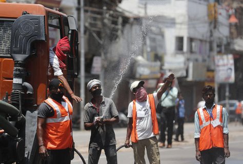 Städtische Angestellte in Prayagraj desinfizieren eine Fläche.