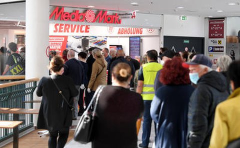 Kunden in Wien warten in einem Einkaufszentrum auf die Öffnung eines Elektronikmarktes. Seit Samstag dürfen auch große Geschäfte in Österreich wieder öffnen - weiterhin gelten aber strenge Hygieneregeln.
