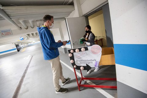 Ein Mitarbeiterin der Stadtbibliothek in Böblingen bringt in einer Tiefgarage an einem 
