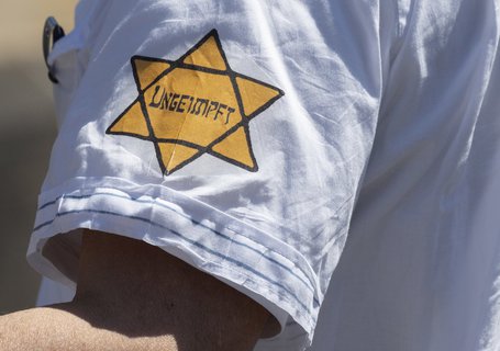 Ein Demonstrant in Frankfurt trug einen dem NS-„Judenstern“ nachempfundenen Aufnäher mit der Aufschrift „Ungeimpft“ am Ärmel. Bei verschiedenen Corona-Protesten fielen Demonstranten mit antisemitischer und den Nationalsozialismus verharmlosender Symbolik auf.