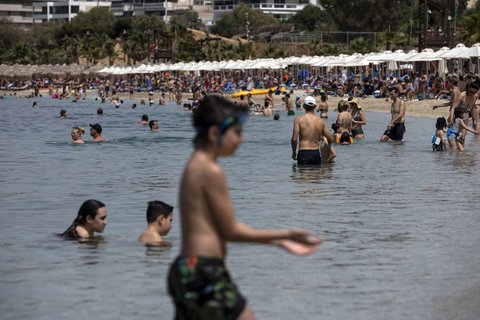 Menschen baden am Samstag im Mittelmeer am Strand von Alimos in der Nähe von Athen.