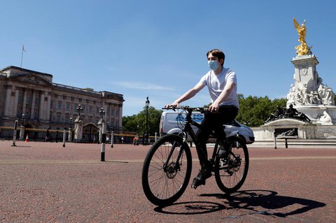 Ein Radfahrer vor dem Buckingham-Pallace in London