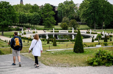 Besucher gehen durch den Park des Schlosses Sanssouci