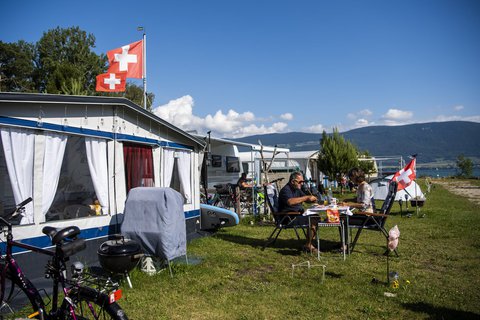 Camper beim Frühstück mit Blick auf den Neuenburgersee. Die Schweiz hat fast alle Corona-Schutzmaßnahmen aufgehoben.