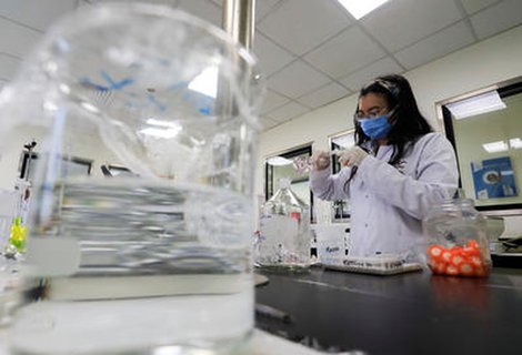 Labormitarbeiterin untersucht das Coronavirus.