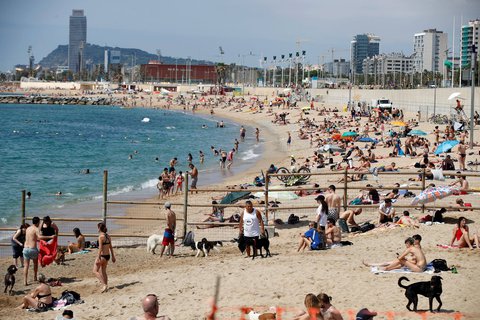 Bald mit Maske? Menschen sonnen sich am Strand in Barcelona. 