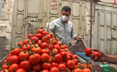 Ein Mann in Nablus kauft bei einem Straßenhändler ein.
