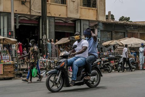 Zwei Motorradfahrer mit Mund-Nasenschutz in Senegal