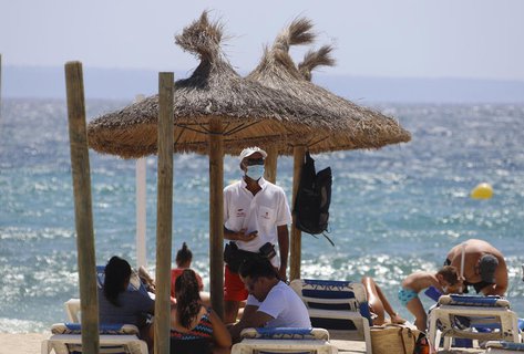 Strandliegenverleiher mit Maske 