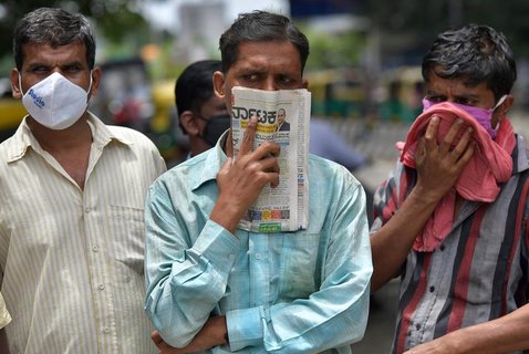 Männer warten auf einer Straße in Bangalore.