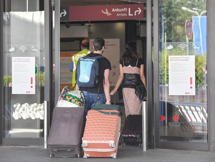 Reisende gehen in Berlin-Schönefeld zum Terminal.