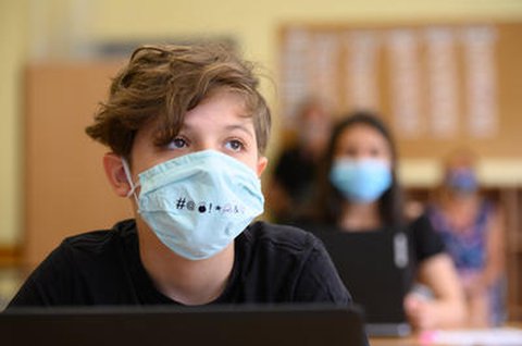 Ein Schüler sitzt mit Maske im Unterricht