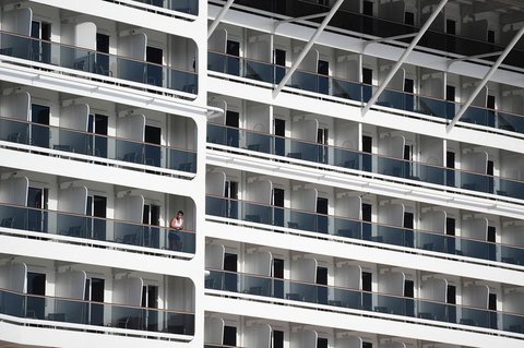 Ein Mann steht auf dem Balkon seiner Kabine.