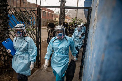 Mitarbeiter des peruanischen Gesundheitsministeriums gehen in Lima zu einer Teststation.