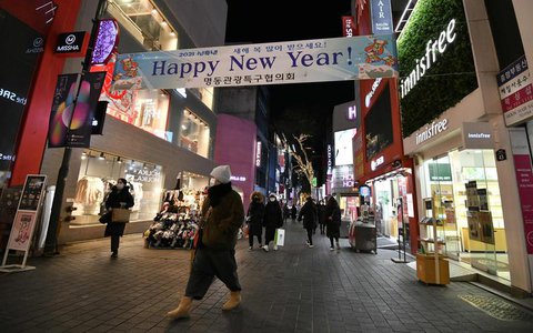Menschen auf einer Einkaufsmeile in Seoul am Abend vor Silvester.