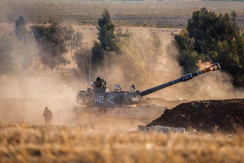 Militärfahrzeuge der israelischen Armee feuern in 
Richtung Gazastreifen. 