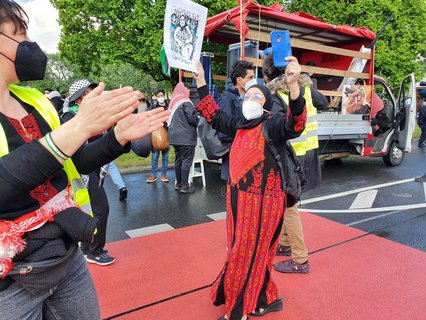 Am Oranienplatz wächst die Zahl der Demonstranten schnell,  es sind schon mehr als 1000. Eine Frau tanzt. Die Menge skandiert 