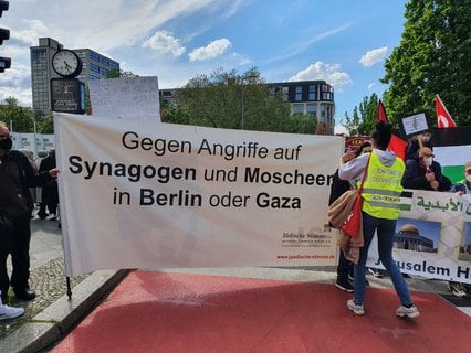 Dieses Transparent ist an der Spitze zu sehen. Am Oranienplatz ist die Stimmung völlig friedlich. Aber bei den Polizisten baumeln die Helme bereits am Gürtel.