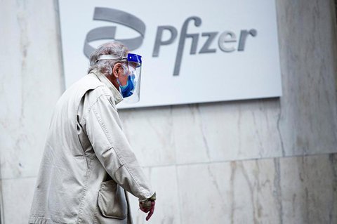 Ein Mann mit Gesichtsmaske und Schild im Pfizer-Hauptquartier in New York.