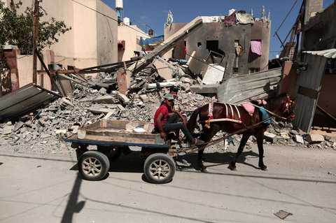 Zwei Männer vor einem zerstörten Haus im Gazastreifen.