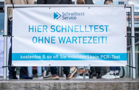Menschen stehen vor einem Testzentrum in Stuttgart.