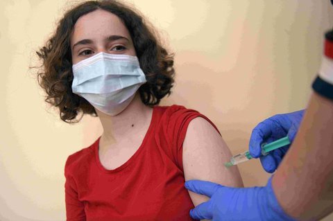 Eine 13-jährige Schülerin bekommt eine Impfung.