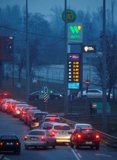 Autos stehen Schlange vor einer Tankstelle in Kiew.