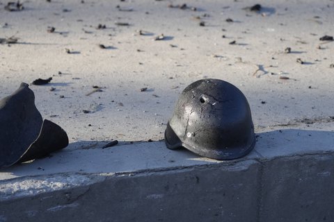 Ein Helm mit einem Einschussloch liegt im umkämpften Kiew auf der Straße.