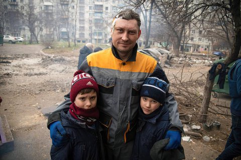 Ein Vater mit einer Verletzung am Kopf steht mit seinen zwei Söhnen in Mariupol. Immer noch toben heftige Kämpfe in der Stadt. 