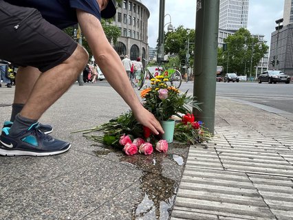 Paul (47) ist Physiotherapeut und arbeitet in der Nachbarschaft. Am Donnerstag legt er Blumen an der Ecke Ku'damm/ Rankestraße nieder und holt extra einen Becher mit Wasser für einen Strauß.