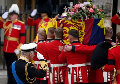König Charles III. salutiert vor dem Sarg von Königin Elizabeth II., der mit der königlichen Standarte, der Imperial State Crown und dem Reichsapfel und Zepter bedeckt ist, während er zum Staatsbegräbnis in die Westminster Abbey getragen wird.