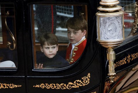 Prinz George (r) und sein Bruder Prinz Louis, fahren nach der Krönungszeremonie von König Charles III. und Königin Camilla im Westminster Abbey in einer Kutsche zum Buckingham Palace zurück.