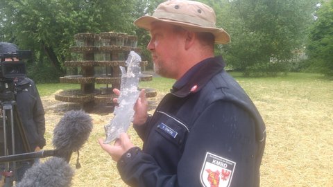 Sprengmeister Schwitzke hält einen Bombensplitter in der Hand.