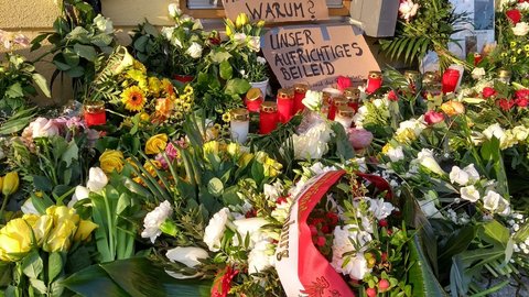 Blumen, Kerzen und Schilder erinnern an die Opfer.