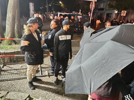 Der rechte Streamer Sebastian Weichreite wird am Rande der Versammlung von Antifa-Aktivisten mit Schirmen abgedrängt. Vergleichbare Situationen kommen häufig vor. Auch diesmal verläuft die Konfrontation routiniert – eine junge Frau zwischen den Schirmen ruft dem Streamer zu: „Geh' mal zu einem Aussteiger-Programm.“