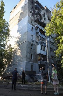 Anwohner betrachten ein Wohnhaus in Odessa.