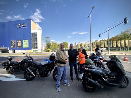 Vier Motorrad- und Roller Fahrer warten auf die Eröffnung der Autobahn